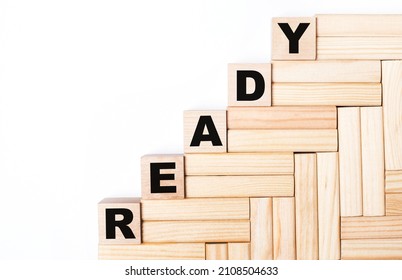 On a light background, wooden blocks and cubes with the text READY - Shutterstock ID 2108504633