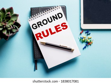 On a light blue background, there is a potted plant, a tablet and a weekly with the text GROUND RULES.
