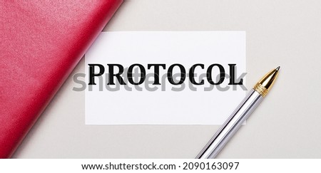 On a light gray background, there is a golden pen, a burgundy notebook and a white blank card with a place to insert text PROTOCOL Business concept.