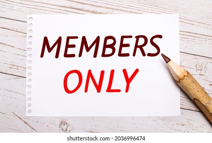 On A Light Wooden Background, A Colored Pencil And A White Sheet Of Paper With The Text MEMBERS ONLY