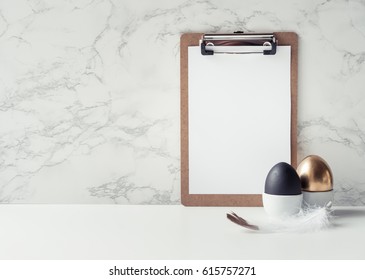 On a marble background a layout for text with Easter eggs golden and black. Style minimalism