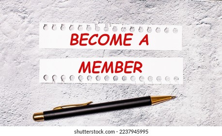On a marble background are two torn strips of white paper with the text BECOME A MEMBER and a black pen.