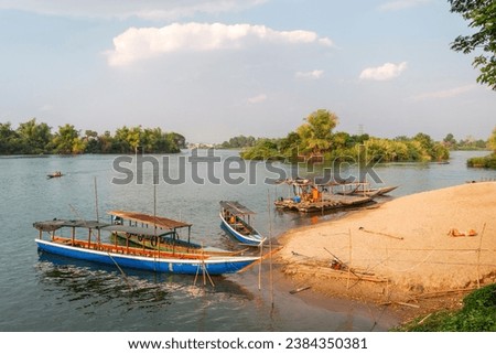 On the Mekong river,small wooden boats transport people to and from Nakasong and Don Som Islands,at the sandy beach pier point,main route onto Don Det Island.