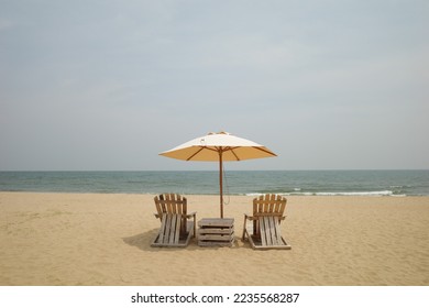 On middle frame Beach Wooden chairs and a parasol on sand beach