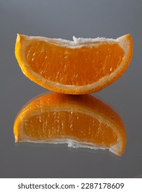 On the mirror table is a slice of oranges. from which the reflection comes.