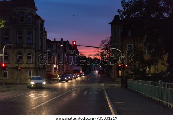 on an october fall evening\
buildings, lightened windows and streets the sky is illuminated\
with rainbow colors in a historical city of south germany near\
stuttgart
