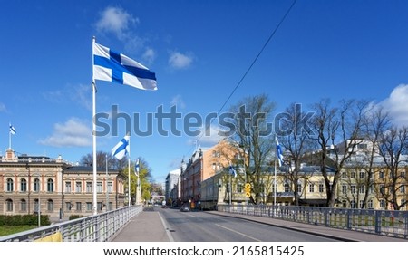 On official flag days, Finnish flags fly everywhere in the city. The city is still quiet on a Sunday morning before the shops open. Photo taken in Turku, Finland.