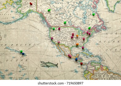 On Old Antique Paper Map Of America With Holiday Destinations Market With Colourful Cork Board Pins.