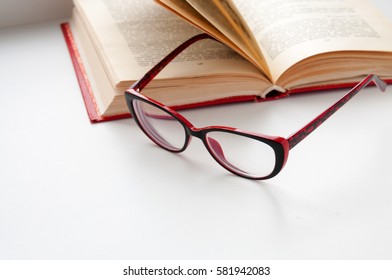 On the open book glasses lie on a light background