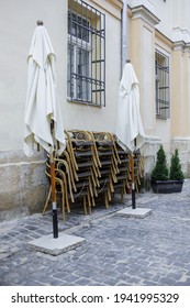 On The Open Terrace Of The Restaurant, Tables And Chairs Are Folded During The Lockdown Due To The Coronavirus Pandemic. Concept Of Travel Crisis, Economic Crisis, No People During `COVID -19 Closure.