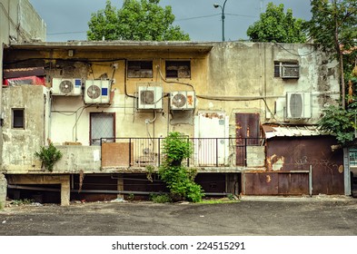 On The Part Of The Backyard, Fashion Shop Looks Very Badly. Shabby Wall, Rusty Doors And Windows, Wires, Air Conditioners, Etc.