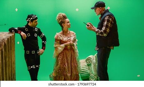 On Period Costume Drama Film Set: Beautiful Smiling Actress Wearing Renaissance Dress And Actor Wearing Motion Capture Suit Listen To Movie Director Explaining To Her Scene Context.