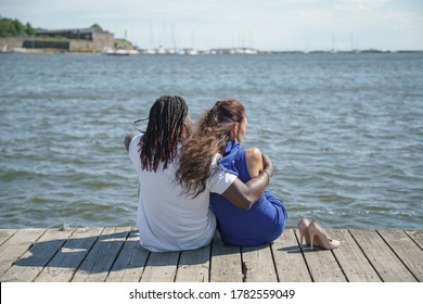 On a pier by the sea. couple outdoors. mixed pair of lovers, African man and European Caucasian woman. - Powered by Shutterstock