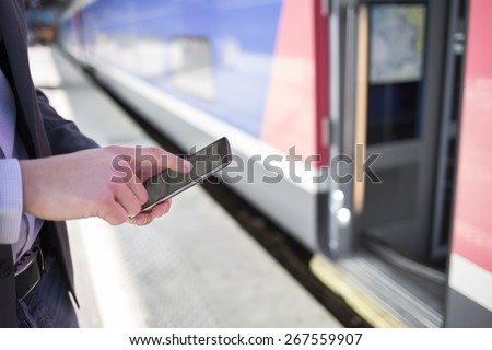 On platform station a man using his cell phone. Close-up hands