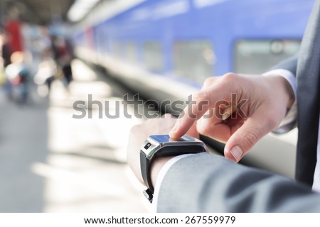 On platform station a man using his smartwatch. Close-up hands