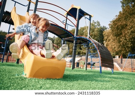On the playground slide. Kids are having fun.