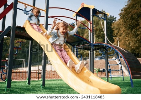 On the playground slide. Kids are having fun.