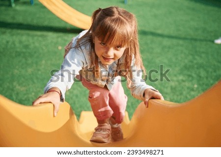 On a playground slide. Little girl is having fun on.