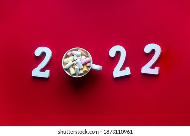 On A Red Background With Wooden White Numbers It Is Written 2022 Instead Of 0 A Mug With Coffee With Marshmellow