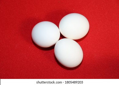 On A Red Doily Three White Oval Eggs
