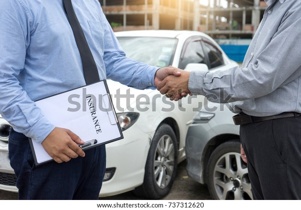 On the road car accident insurance
agent examining car crash  owner and insurance staff make paper
form, handshake for agreement about in insurance
claim