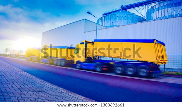 On the road a car for\
transportation of grain . the yellow truck with the trailer .\
Agricultural silos .Tank farm . Commercial transport .  truck\
transport container   . 
