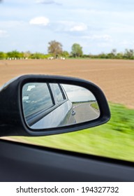 On the road. Empty road reflection in a car mirror.