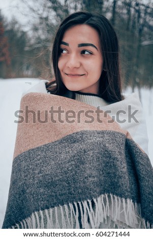 On the road in the forest around snow, cheerful woman holding a handkerchief