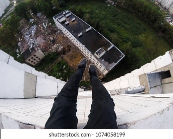 on the roof of the dangling legs. extreme
 - Powered by Shutterstock