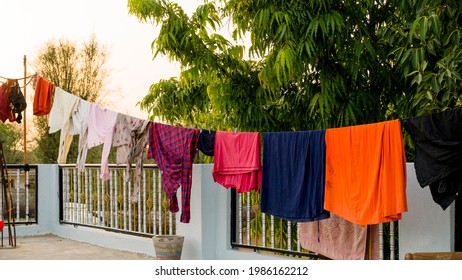 On roof, Rope with clean clothes outdoors on laundry day. Colorful clothes hanging in clothesline.