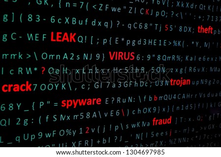 on screen of pc monitor string of words leak, virus, spyware, Trojan denoting types of computer and network threats highlighting in red font among chaotic set of computer green symbols. Side view