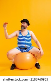 On Sea Beach. Cute Fat Young Man Wearing Retro Striped Swimsuit And Vintage Bowler Hat With Huge Ball Isolated On Bright Yellow Background. Vacation, Summer, Funny Meme Emotions Concept.