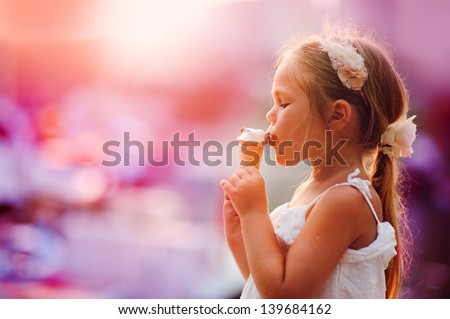 On seacoast the girl eats ice-cream at yachts background