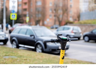 On the side of the road, there is a bright yellow scooter parked next to a car, creating an interesting contrast in the scene - Powered by Shutterstock