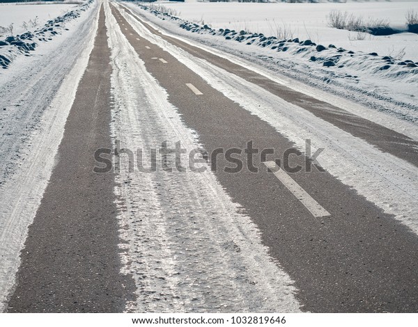On the\
snow-covered road, the dividing strip of the road marking is\
visible. Everything is covered with\
ice.