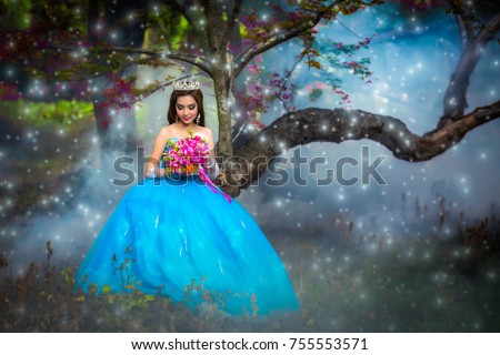 On a snowy night. Beautiful girl wearing princess dress in her hand holding a flower.