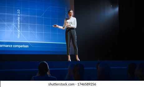 On Stage: Inspirational Female Speaker, Talking About Happiness, Self, Success, Efficiency, Health, And How To Be More Productive. Tech Industry Business Conference Auditorium Hall Full Off People