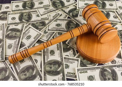 On the stand is a hammer auctioneer, against the background of a lot of dollar bills. - Shutterstock ID 768535210