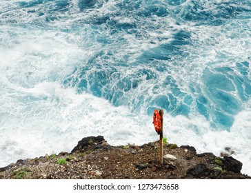 On a steep rocky coast View from above on a red lifebuoy in front of a dangerous wild surf - Location: Spain, Canary Islands, La Palma - Powered by Shutterstock