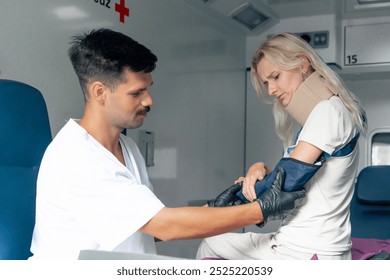 on the street in an ambulance young patient with an injured neck and arm transporting a patient to the clinic a young doctor checking an injured arm - Powered by Shutterstock