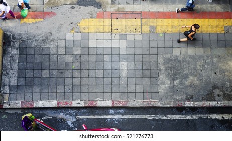 On Street In Top View People Walk On Square Block Pedestrian Walk Way With Yellow And Red Line For Guide Blind People. Person Opens Door Taxi On Street With Shopping Bag (aerial City Street View).