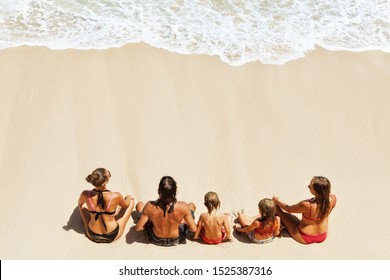 On Sunny Beach Happy Kids With Parents Have Fun, Sit On White Sand See At Sea Surf With Foam And Splashes. Top View. Active Children Lifestyle, Summer Family Vacation Travel On Tropical Family Resort.