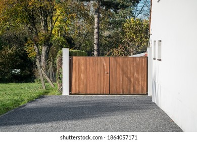 on a sunny day with a wooden garage gate next to a white house
