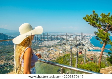 On a sunny summer day, a tourist woman watches the view on the observation decks at the top of the Cable Car on Tunektepe Mountain. The upper station was built at an altitude of 605 m. Stock photo © 