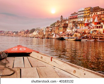 On The Sunset River Bank On The Ganges In India On An Old Wooden Boat.