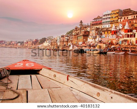 On the sunset river bank on the ganges in India on an old wooden boat.