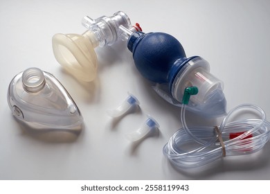 On the table are an Ambu bag with an oxygen mask and medical airways. On a white background. - Powered by Shutterstock