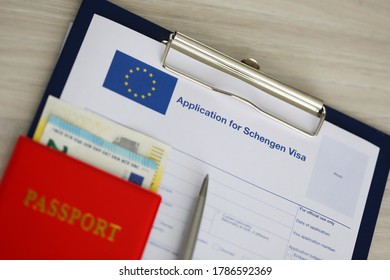 On the table is an application for a Schengen visa. Submission of documents and payment of visa fee - Shutterstock ID 1786592369