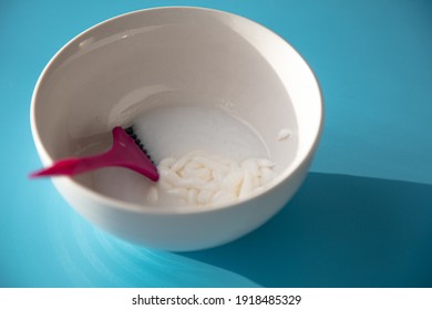 On The Table Is A Bowl With Hair Dye And A Brush. Home Coloring Concept.