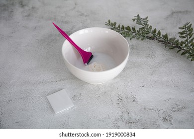 On The Table Is A Bowl With Hair Dye And A Brush. Home Coloring Concept.